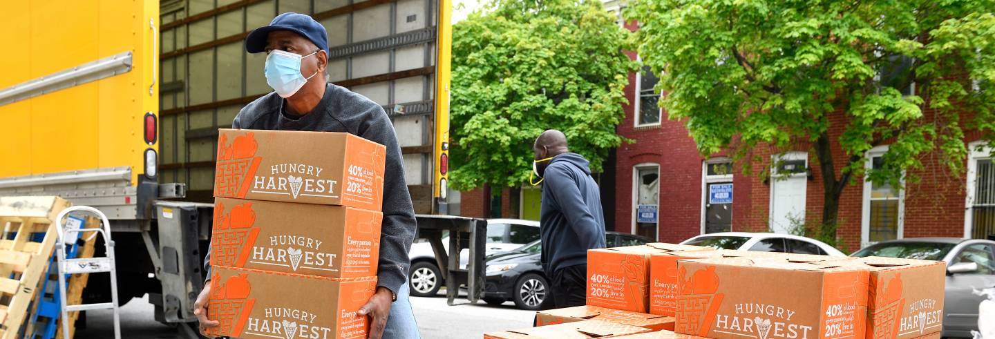 Men unload boxes of food from a truck
